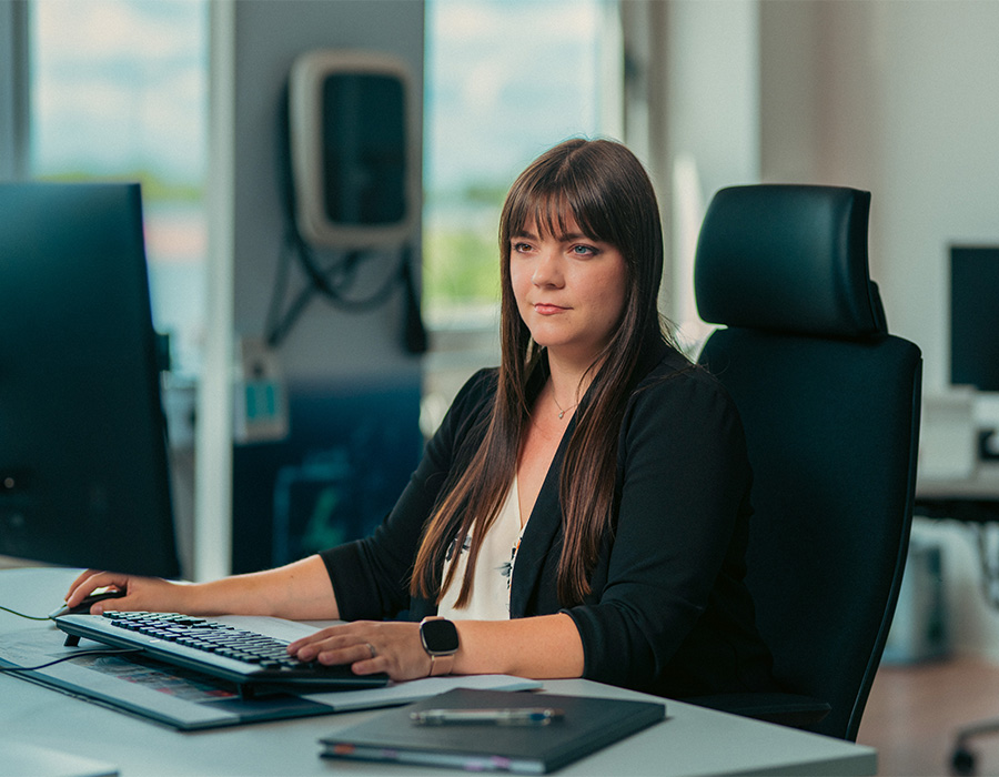 Eine Mitarbeitende im kaufmännischen Bereich arbeitet am Computer im Büro des Unternehmens